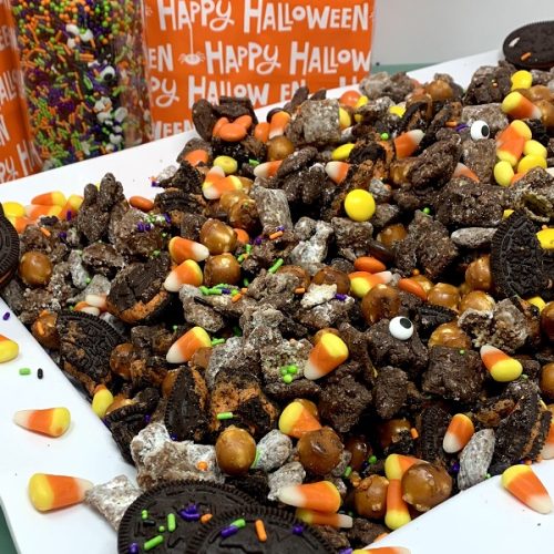 Halloween Puppy Chow Recipe Finished on a Platter with Treat Bags in the Background
