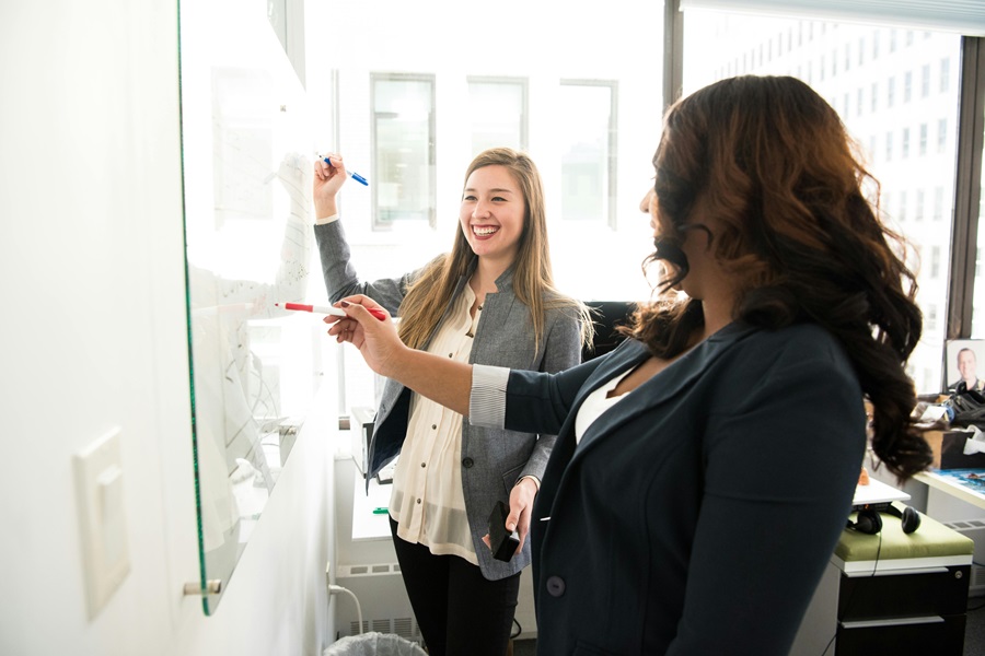 Inspirational Tuesday Motivation Quotes to Keep you Going Two Women in an Office Writing on a Whiteboard