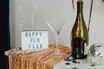 Best Quotes to Ring in the New Year Close Up of a Letterboard Sign That Says 'Happy New Year' Next to a Martini Glass and a Champagne Bottle