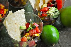 New Years Eve Finger Food Ideas Close Up of a Single Serving of Black Bean Salsa with Chips and Limes