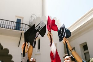 Grad Party Recipes Close Up of People Holding Up Their Graduation Caps